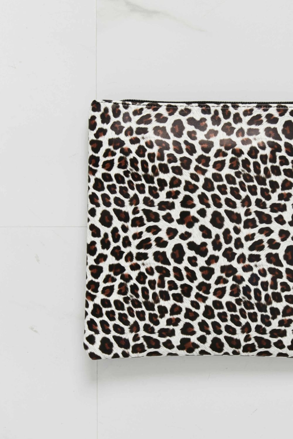 Leopard-print wristlet with top zipper; close-up of patterned front panel