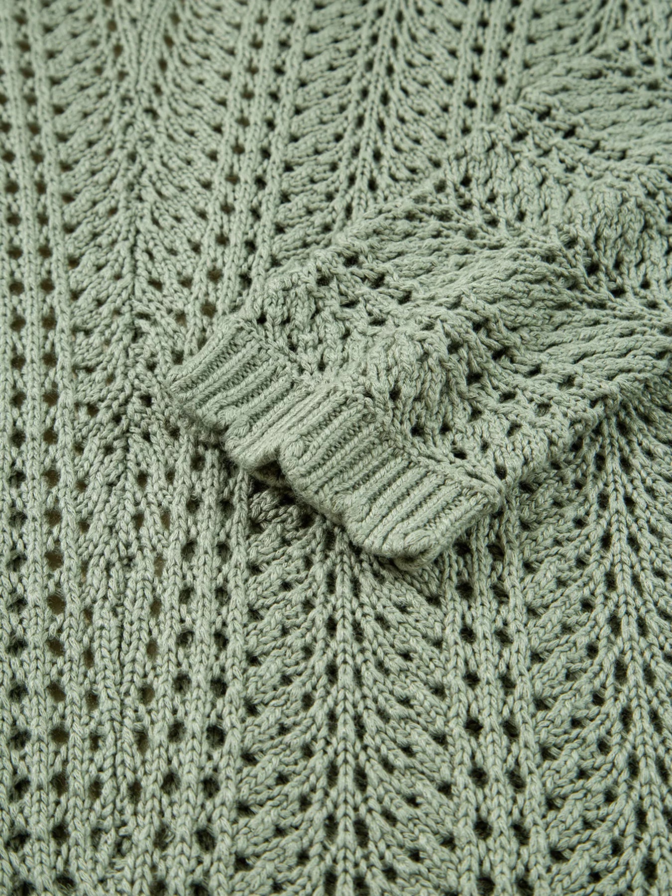 Sage eyelet knit cardigan knit texture detail with scalloped V-shaped seam.