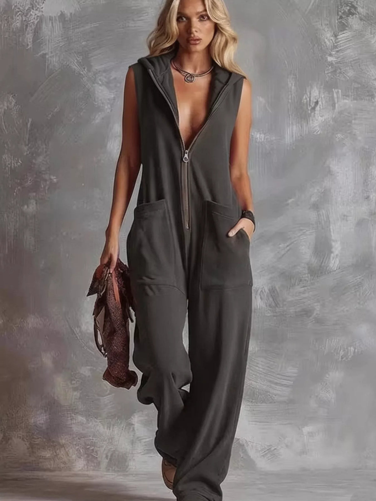 Dark gray sleeveless hooded zip pocket jumpsuit with front zipper and relaxed full legs