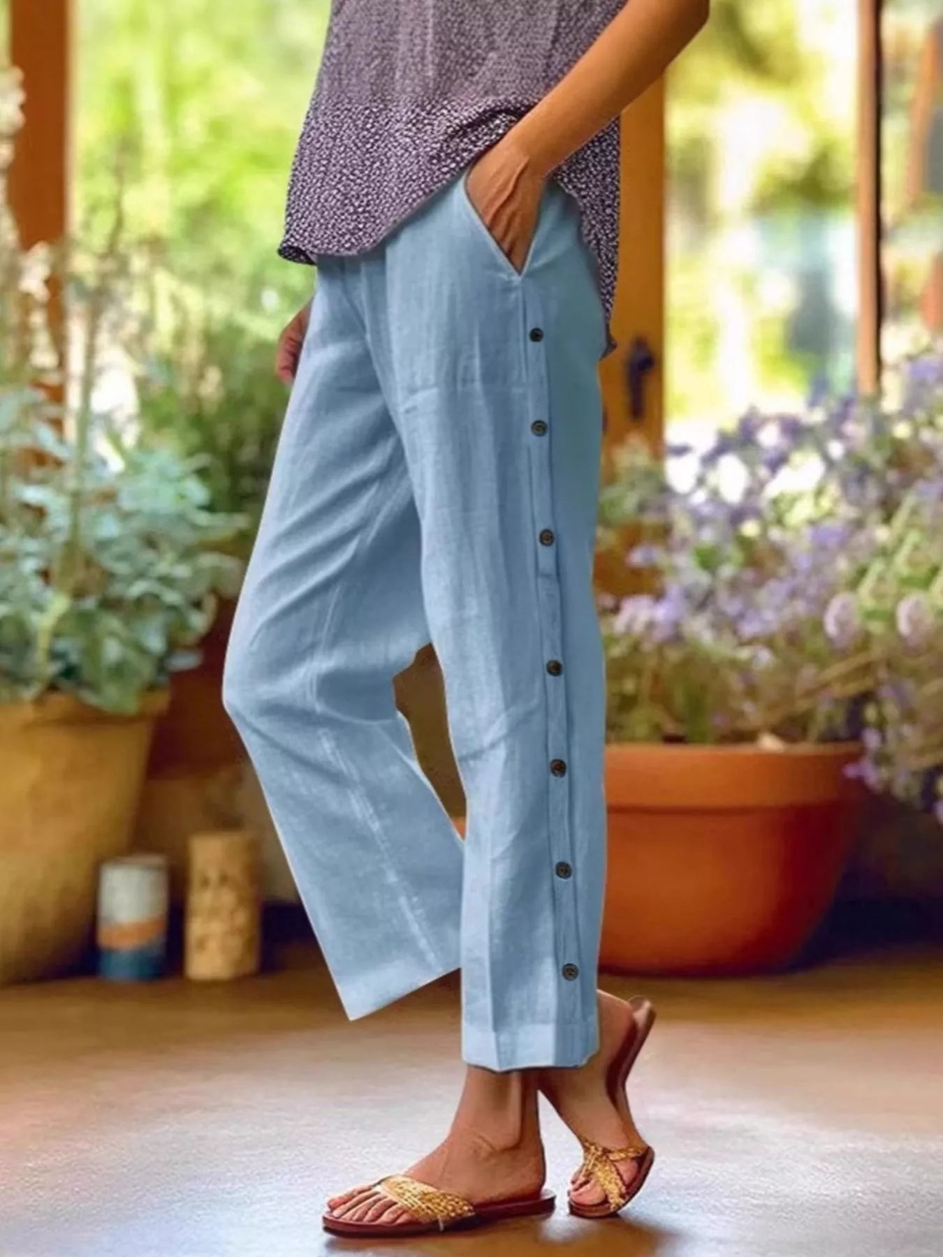 Sky blue polyester pants with side buttons, side pockets, and elastic waistband