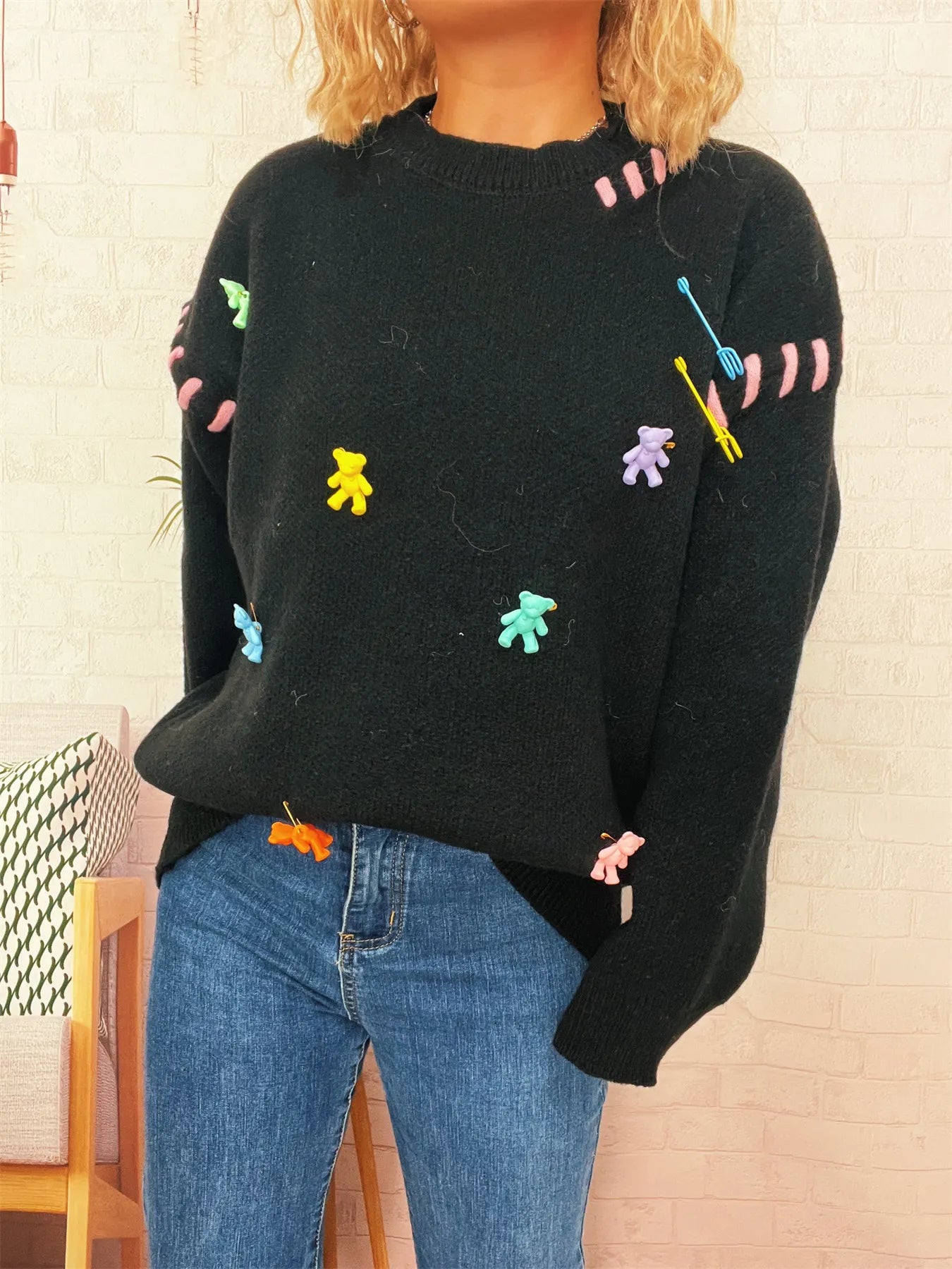 Black round-neck knit sweater with colorful animal graphics on front and long sleeves