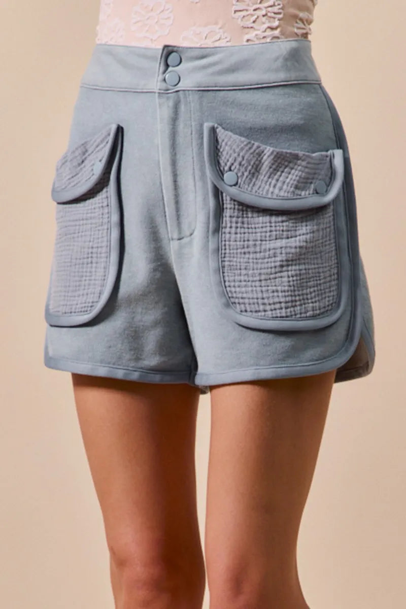 Denim blue mineral-washed terry high-rise cargo shorts close-up of front flap pockets