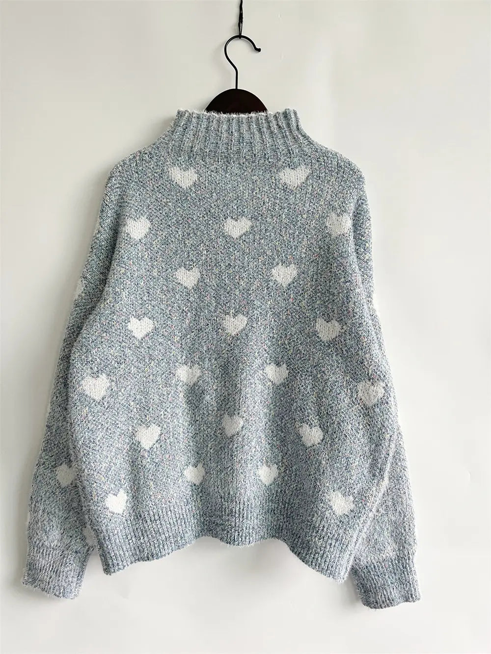 Heart-patterned heathered blue turtleneck drop-shoulder sweater, back view hanging
