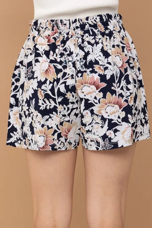 Floral print shorts with elastic waistband, above-knee length, dark background