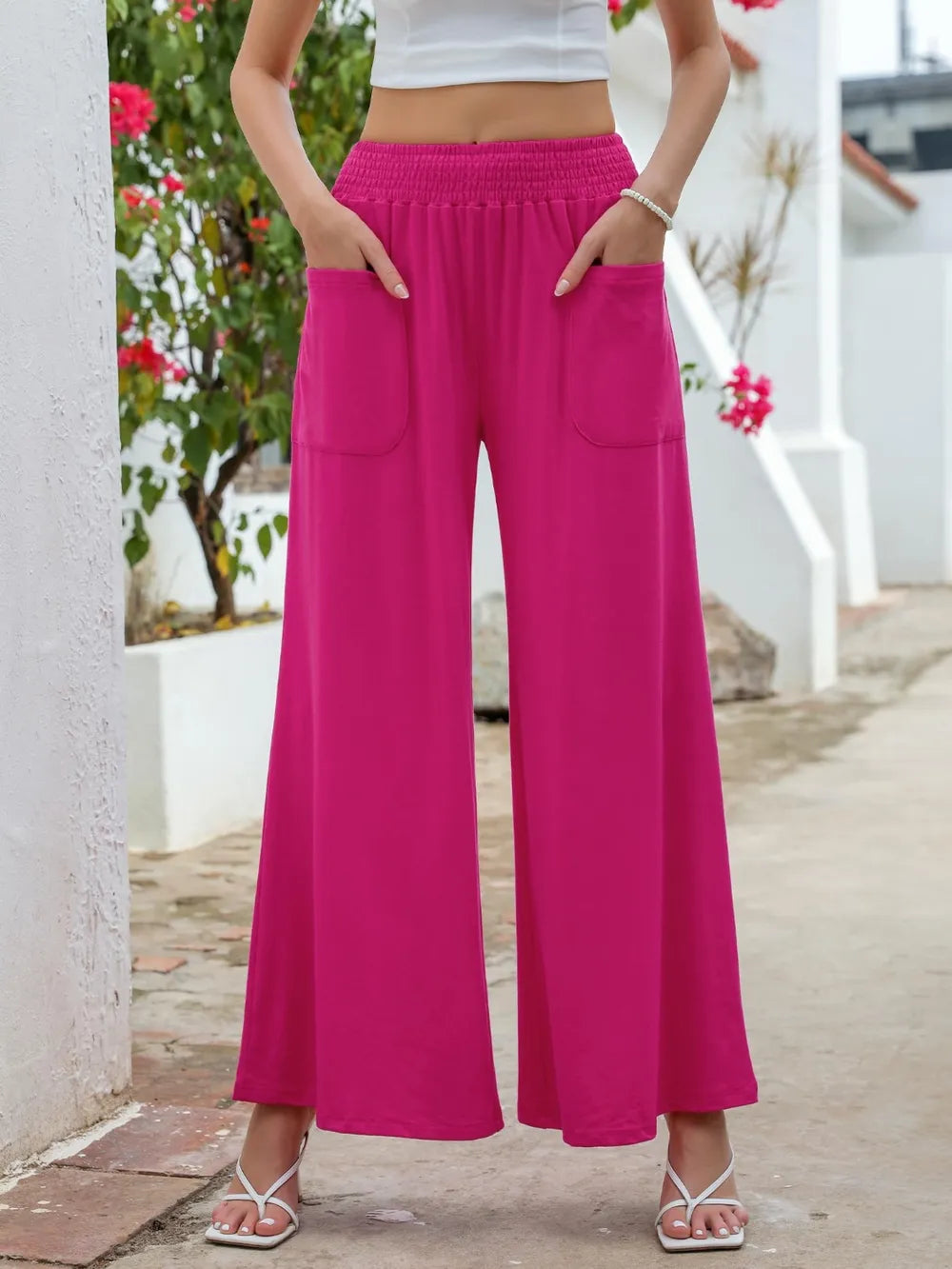 Hot pink wide-leg pants with elastic waist and side pockets, front view with cropped hem