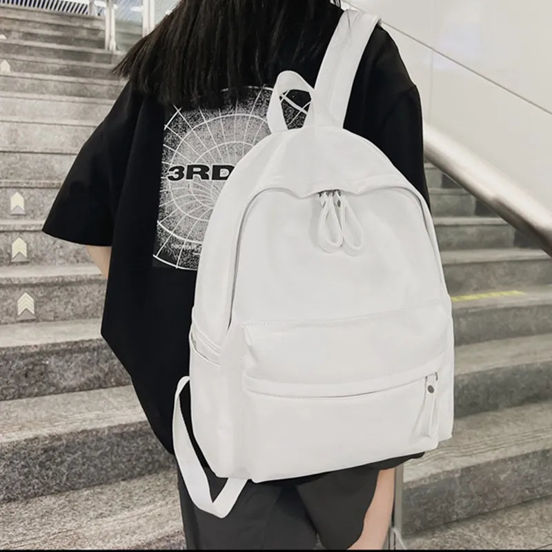 White vegan leather zip backpack with front zipper pocket and drawstring top loop