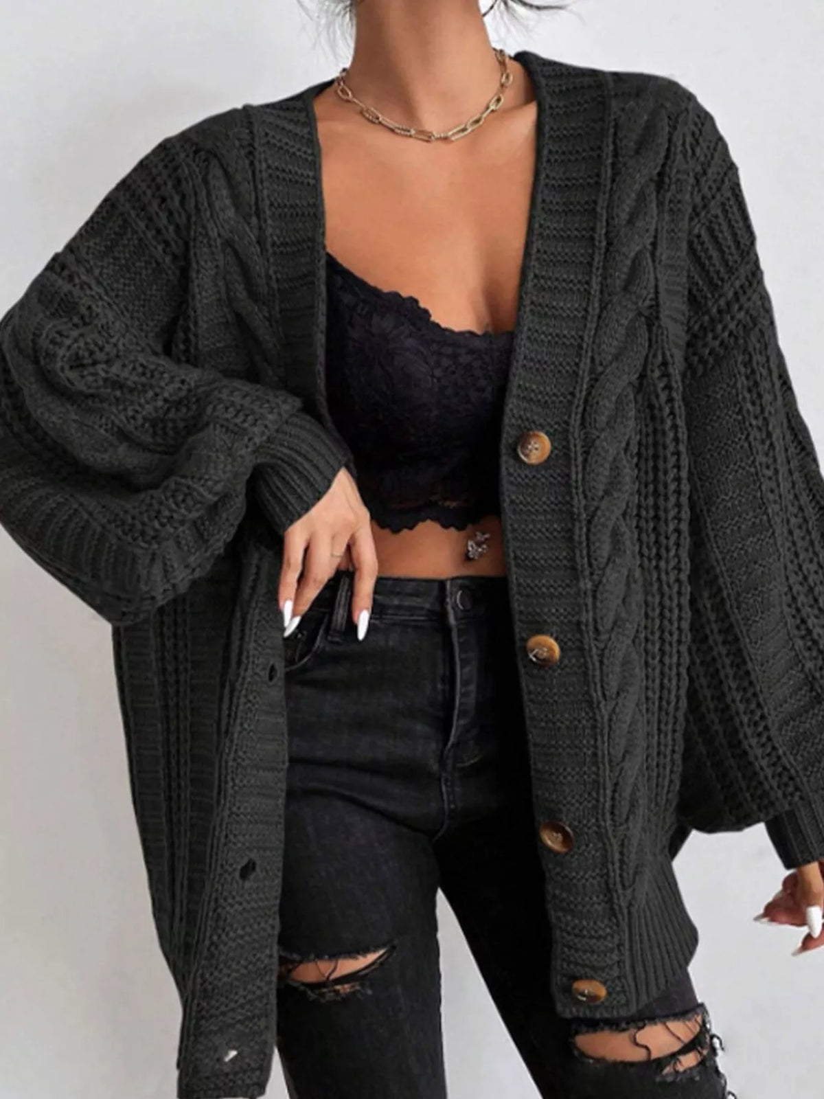Black oversized cable-knit V-neck button cardigan with long sleeves and ribbed trim