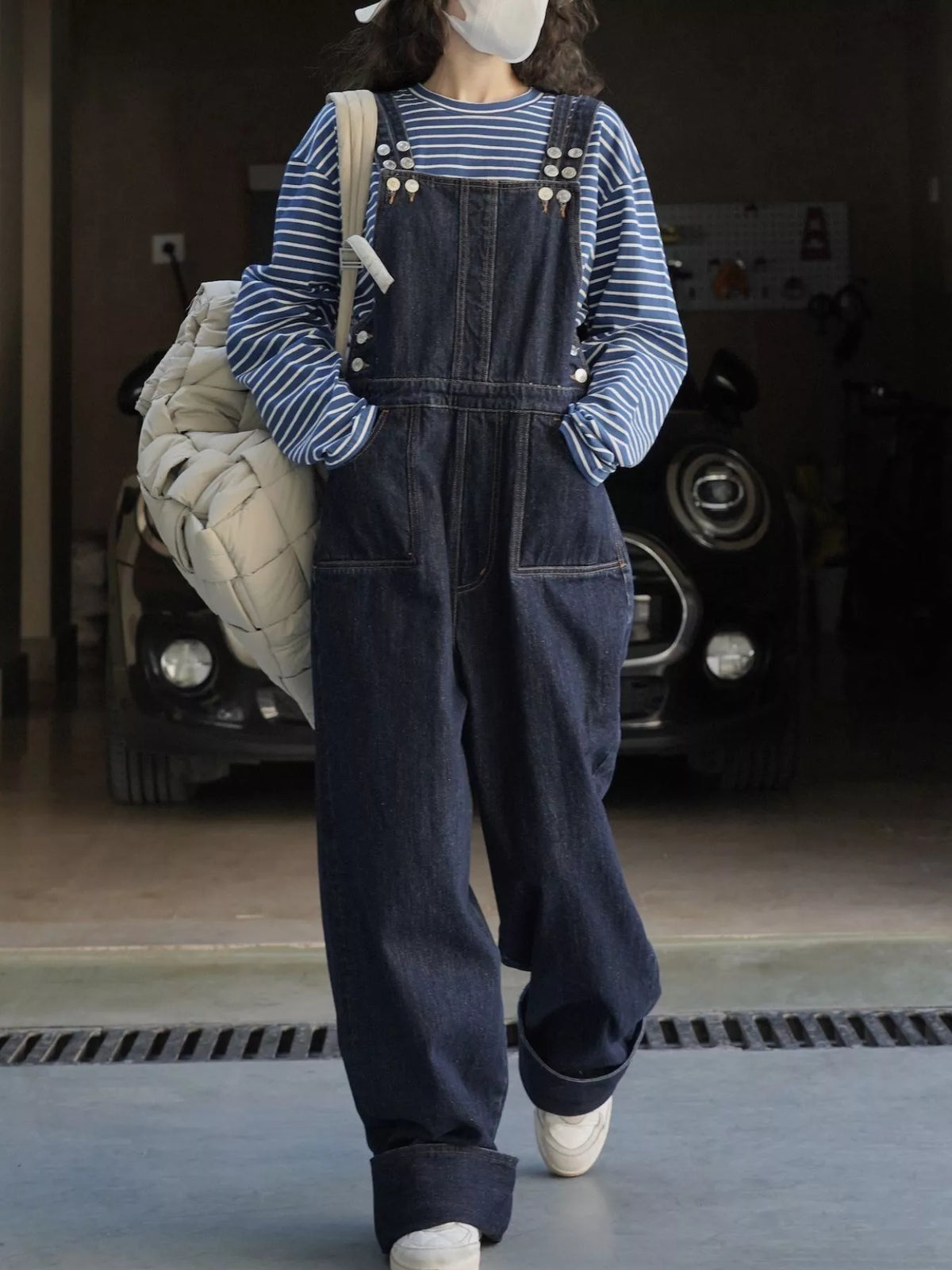 Dark-wash denim overalls with bib front, button straps, and roomy wide legs