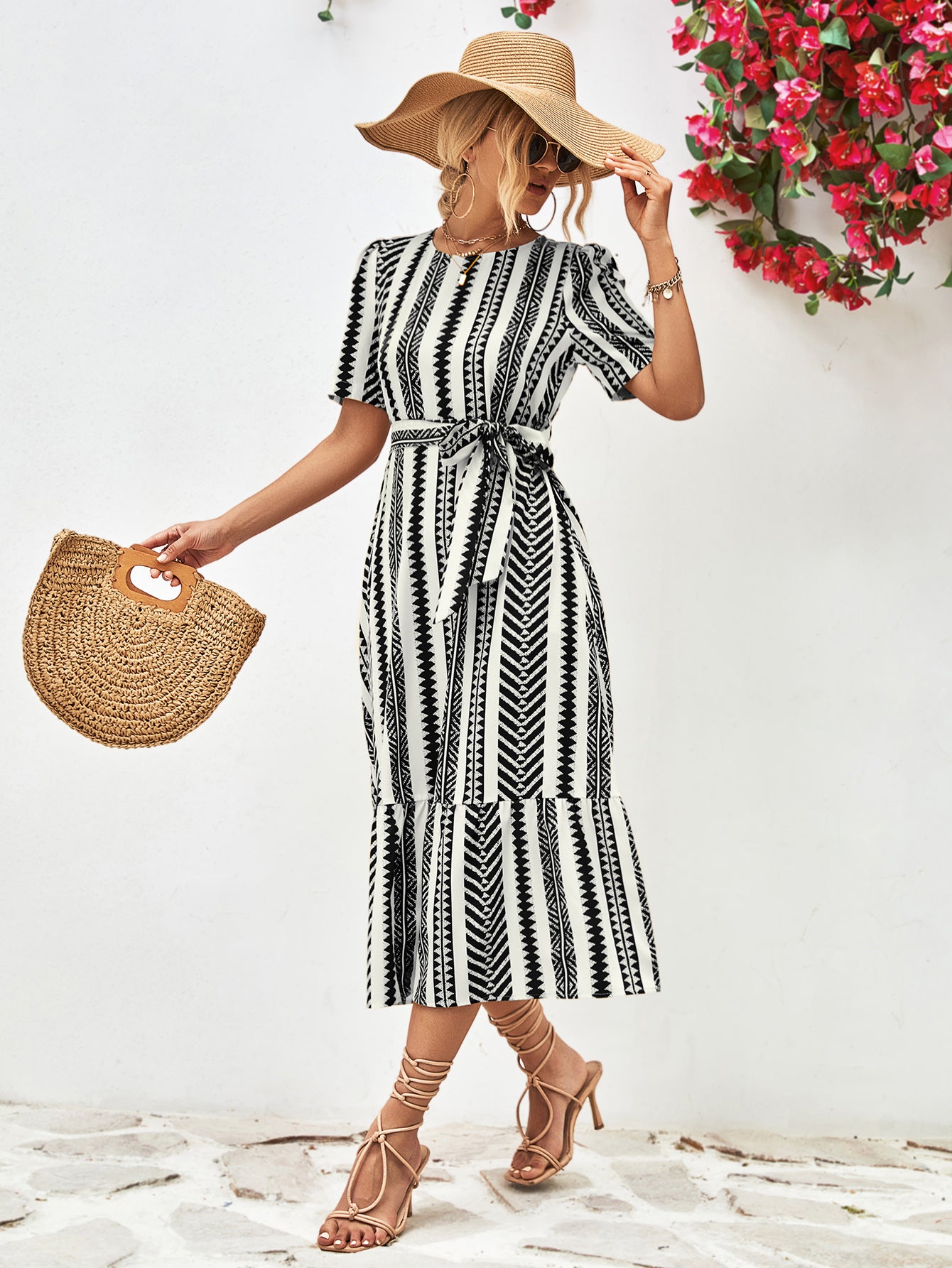 Black striped round-neck puff sleeve dress with tied waist belt, side view with straw hat.