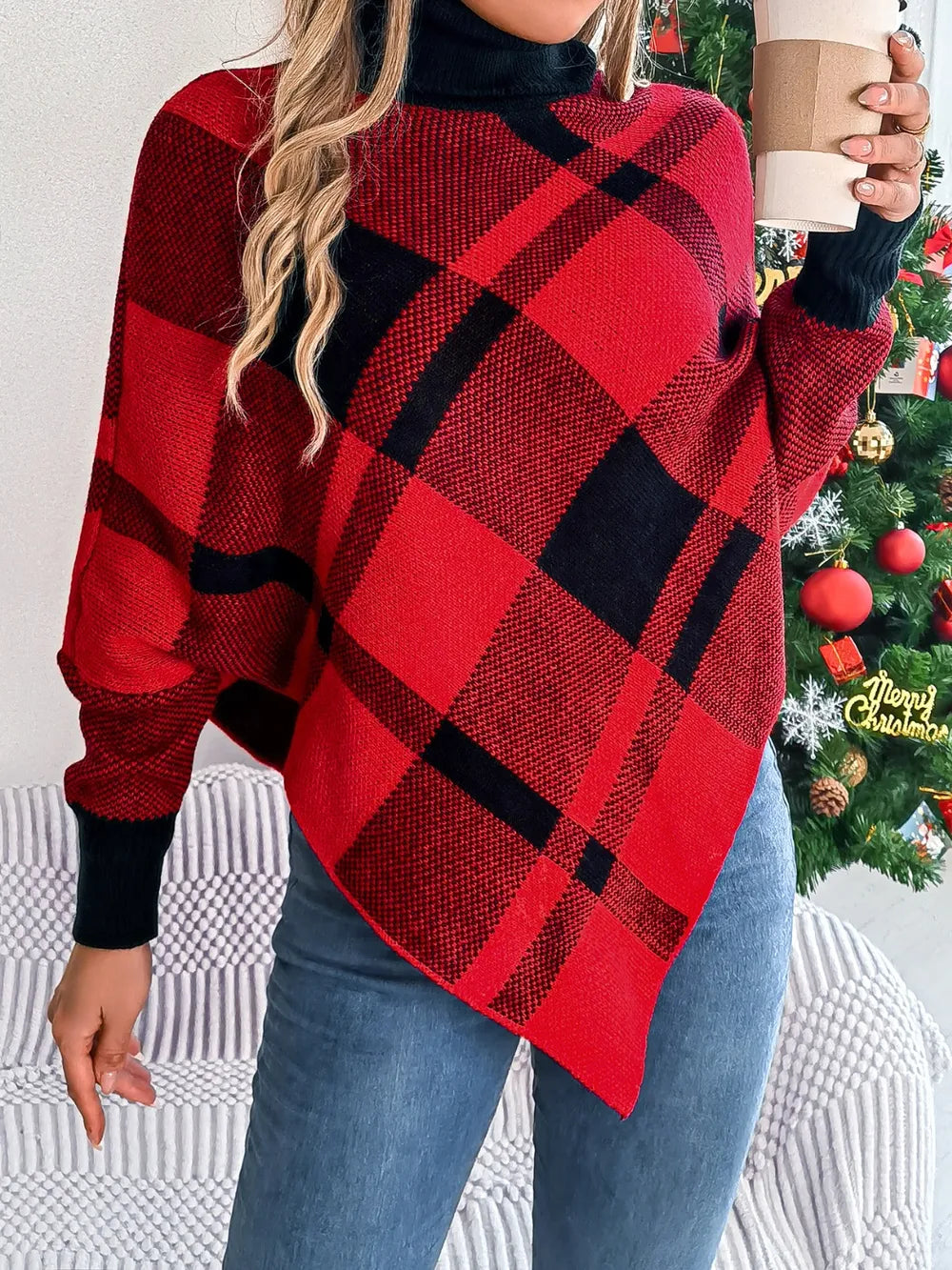 Plaid turtleneck batwing sweater in deep red with black plaid, draped long sleeves.