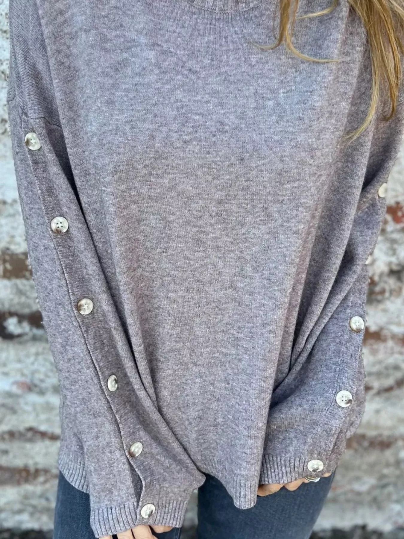Dark gray turtleneck sweater with long buttoned cuffs and ribbed hem