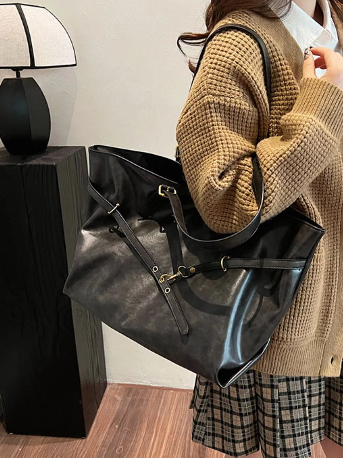 Large vegan leather tote bag, black, side view with wide handles and shoulder strap