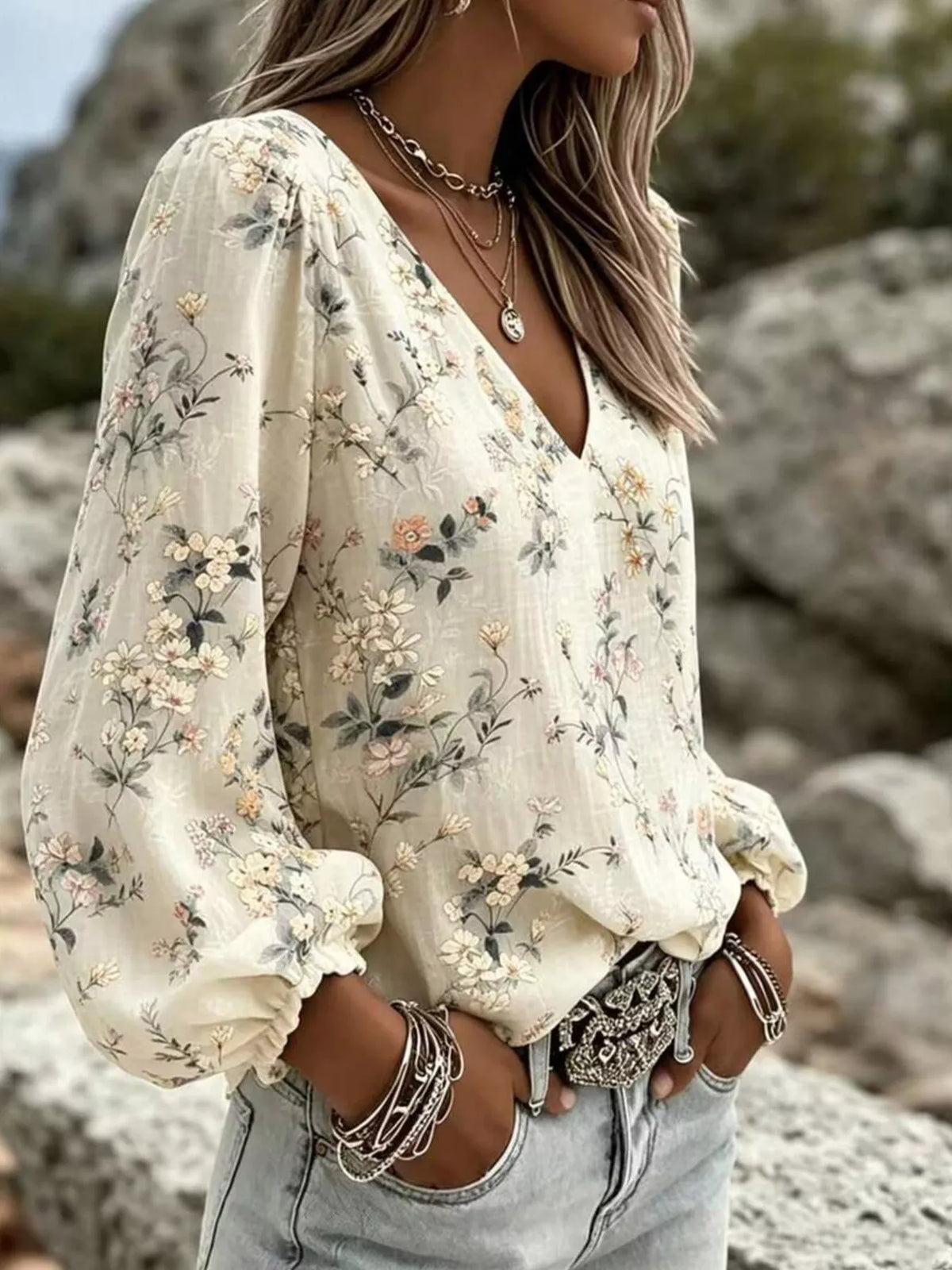 Cream floral v-neck blouse with voluminous puff sleeves and ruched cuffs