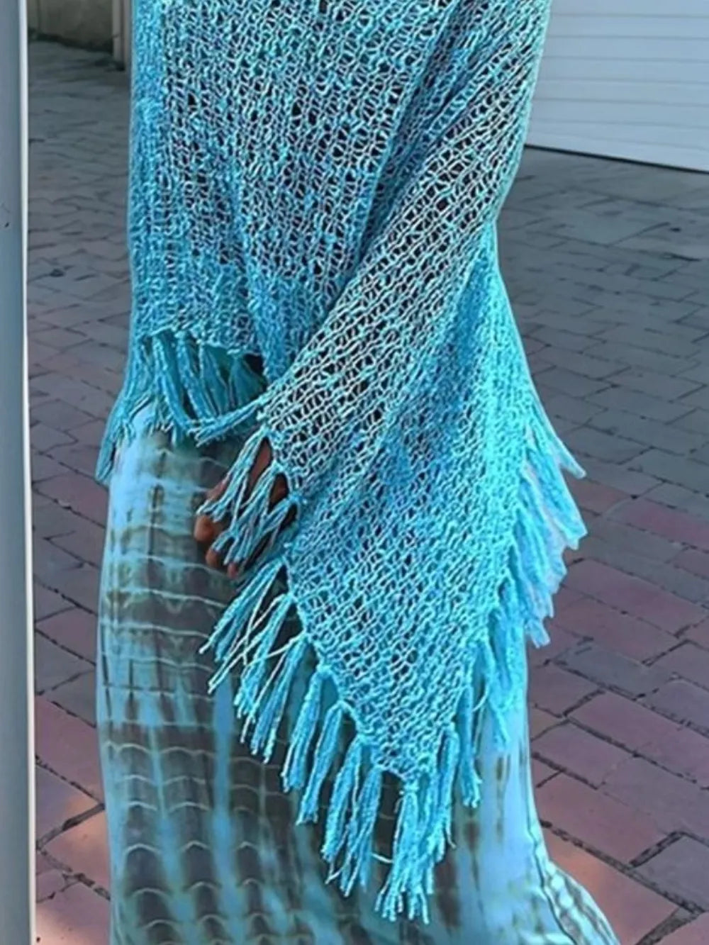 Sky blue knit shawl with fringe tassels along the hem and sleeve