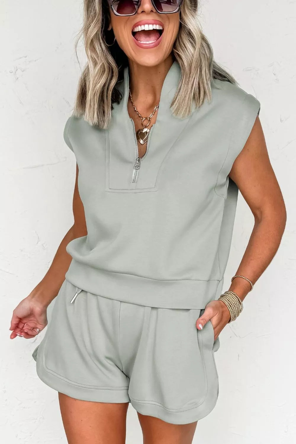 Sage sleeveless quarter-zip top with drawstring shorts, angled front view