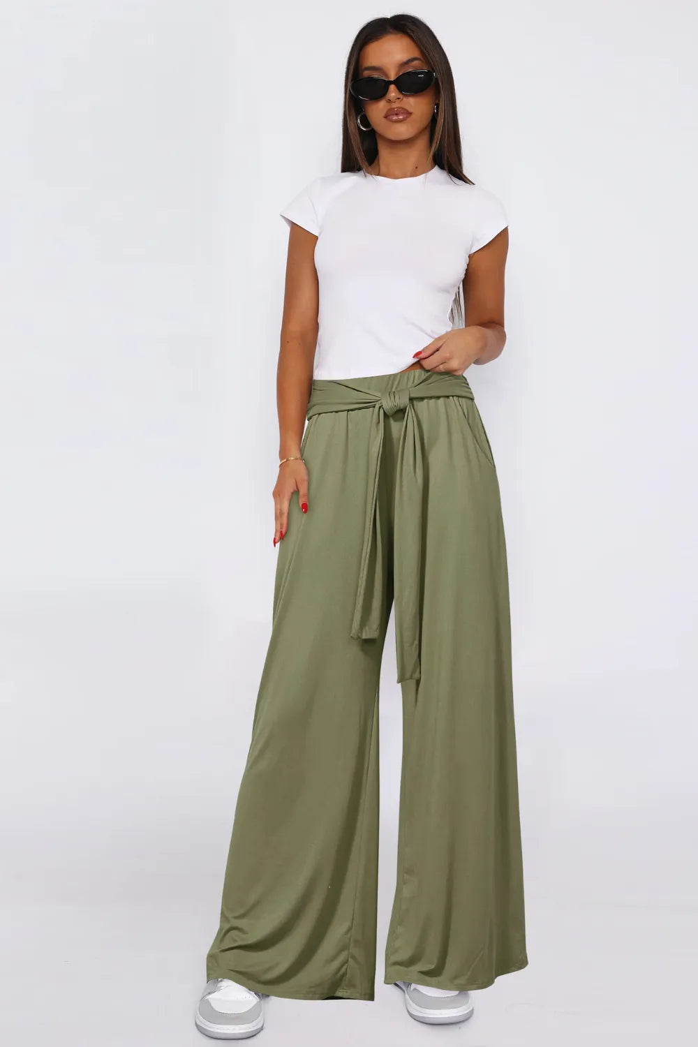 Moss green wide-leg pants with tied waist and side pockets, wide flowing legs.