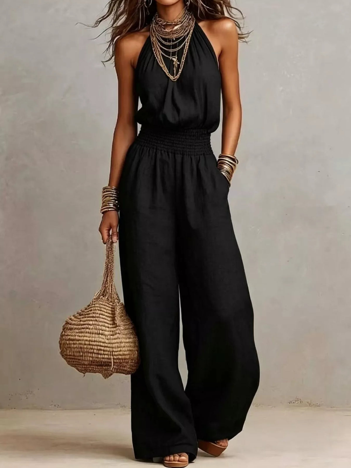 Pocketed halter neck wide-leg jumpsuit in black, sleeveless halter with smocked waist