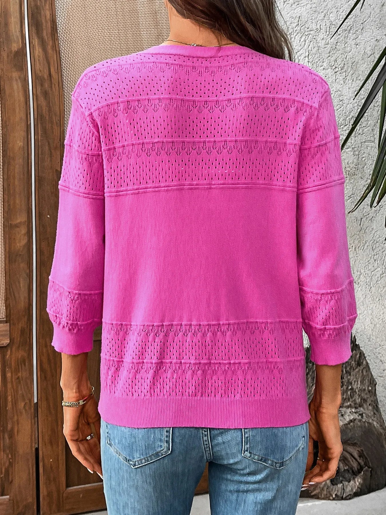 Hot pink textured cardigan with button details and 3/4 sleeves, rear view