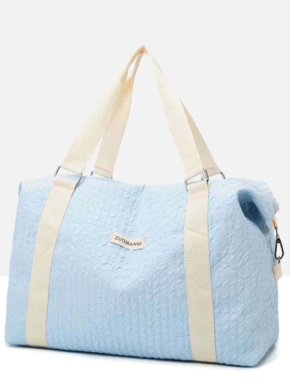 Light blue textured large duffle travel bag with beige handles and shoulder strap