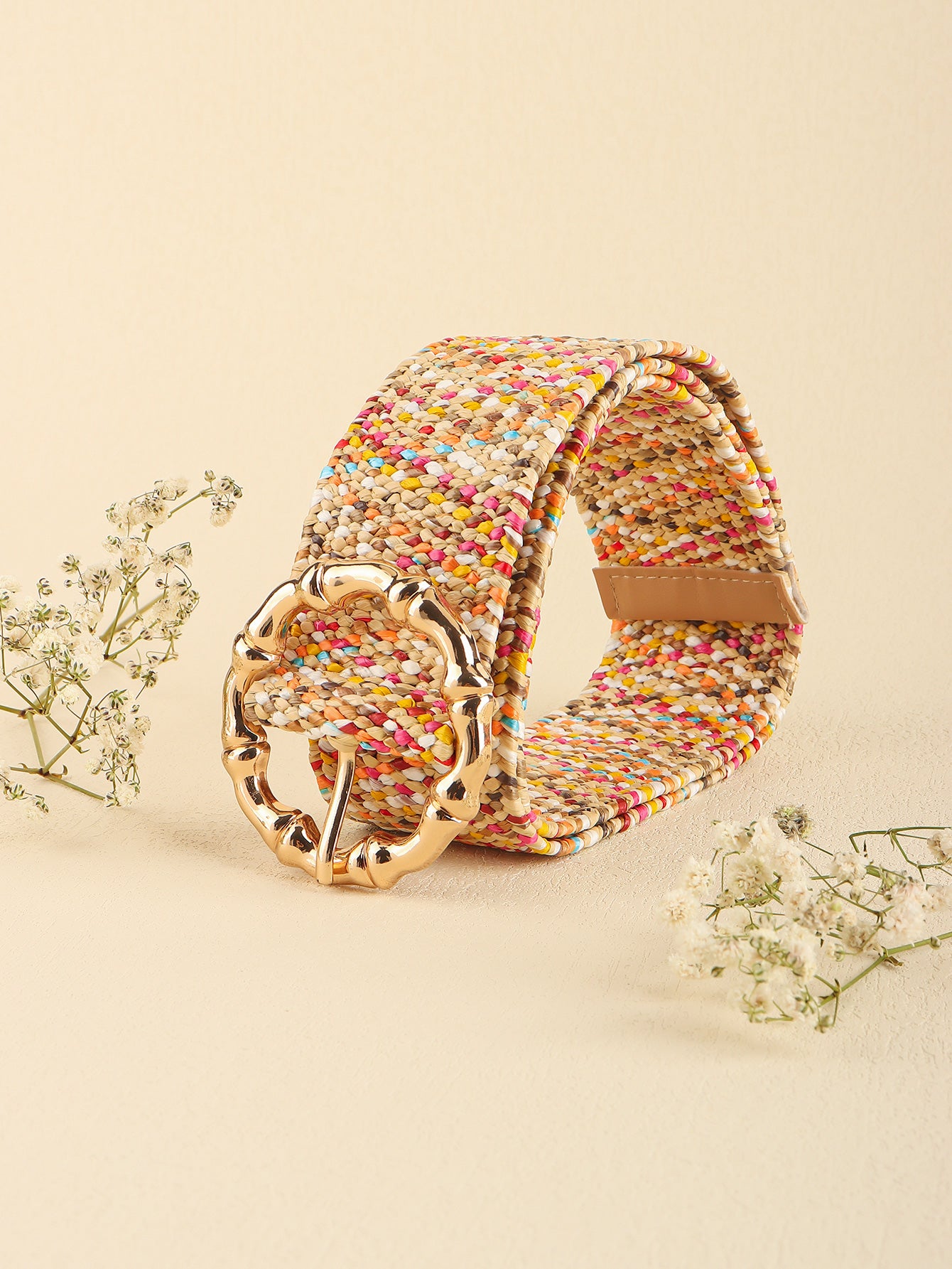 Multicolored wide belt at an angle, woven texture with gold buckle and tan keeper