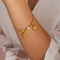 Gold-plated heart charm bracelet with rhinestone bead accents on wrist