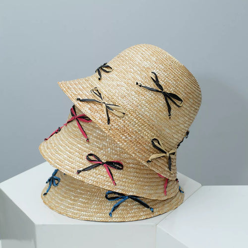 Straw bucket hat with bowknot ribbons on a woven brim, multicolor accents