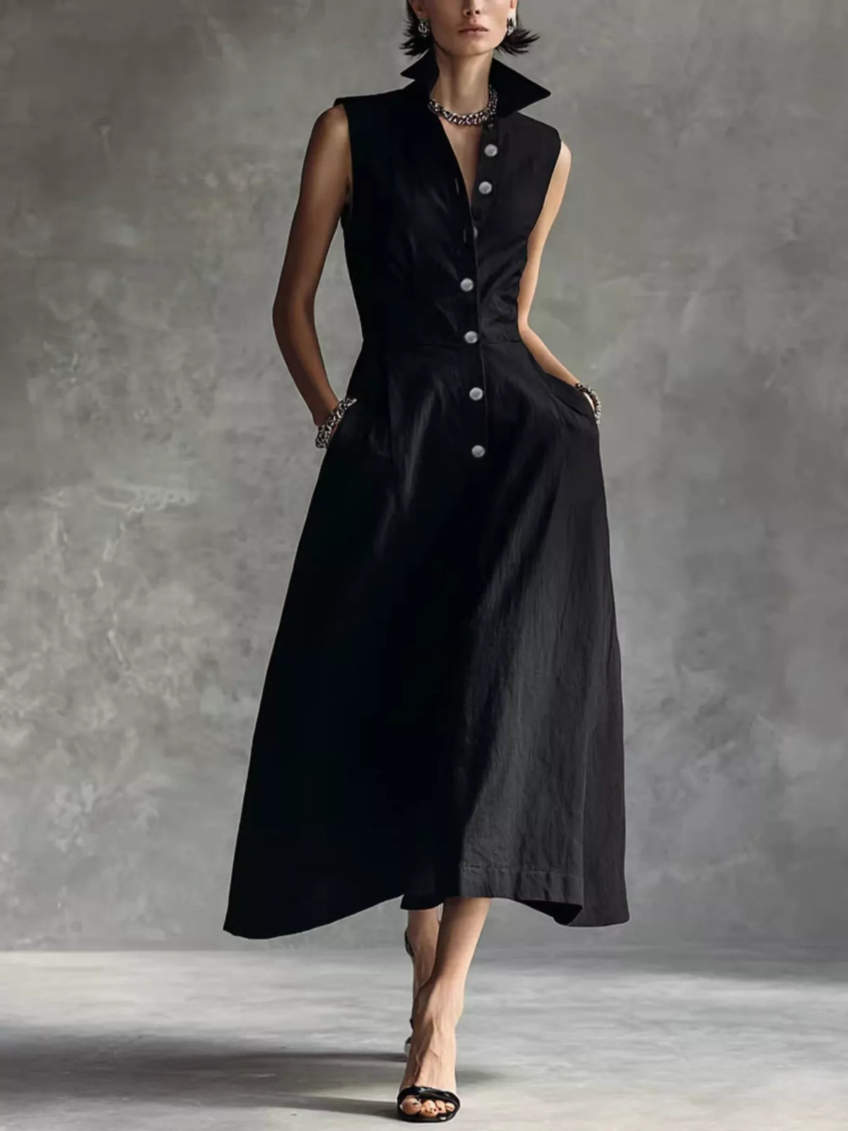 Black sleeveless midi button shirt dress with pointed collar and gathered A-line skirt.
