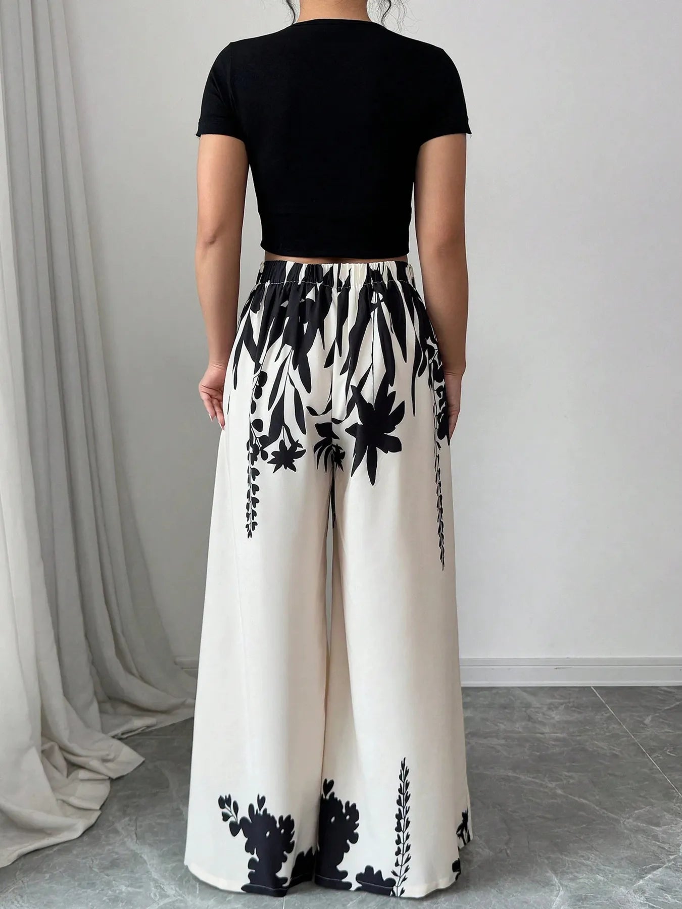 White and black floral printed wide-leg pants, elastic waist, full back view
