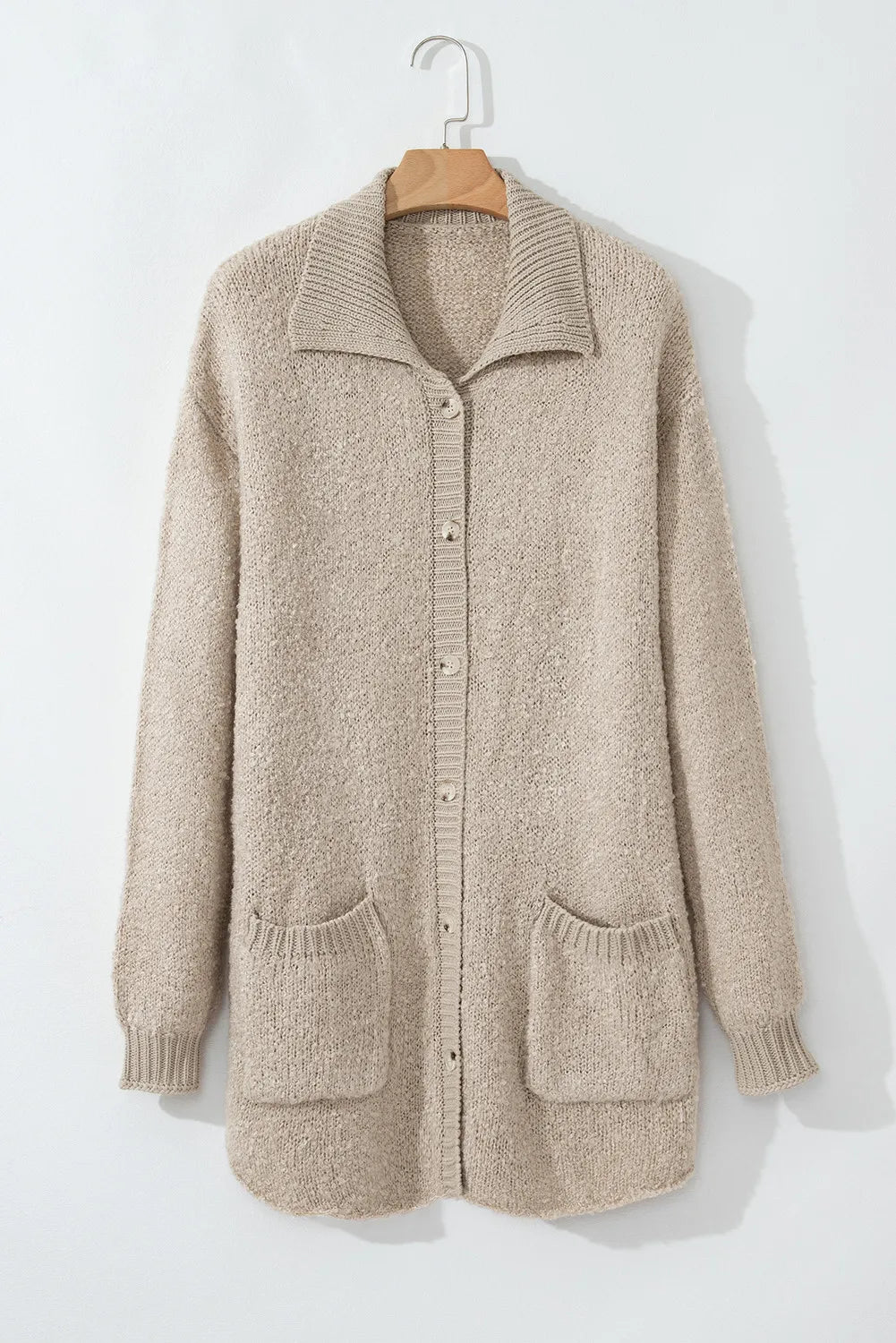 Dust Storm button-up long sleeve cardigan with patch pockets on front, hanging on hanger