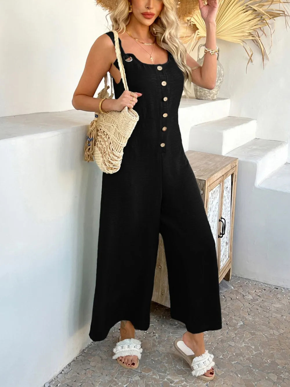 Black button-front wide-leg jumpsuit with square neck and sleeveless straps