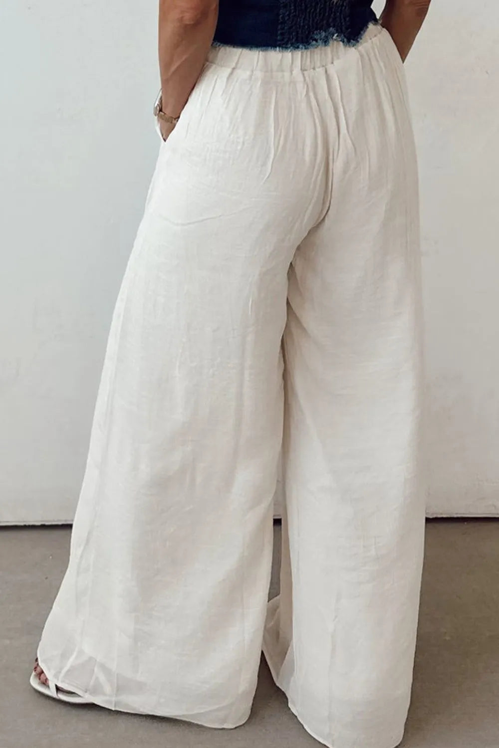 White tie-waist pleated wide-leg pants with wide straight legs and gathered waistband