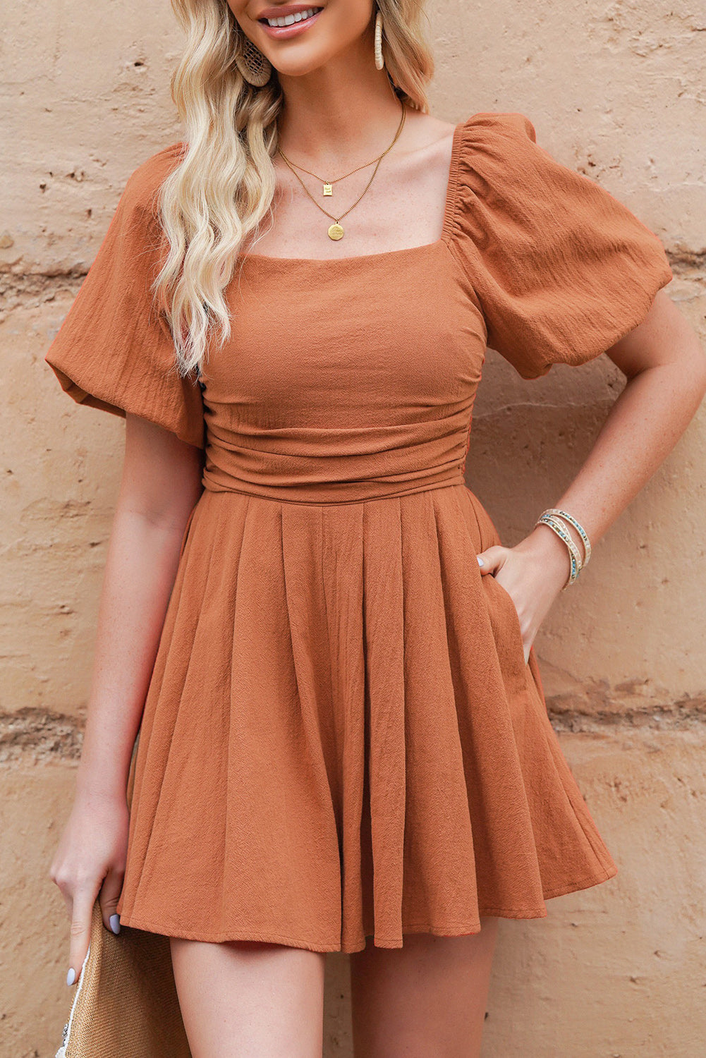 Ochre square-neck pleated romper with short puff sleeves and gathered skirt