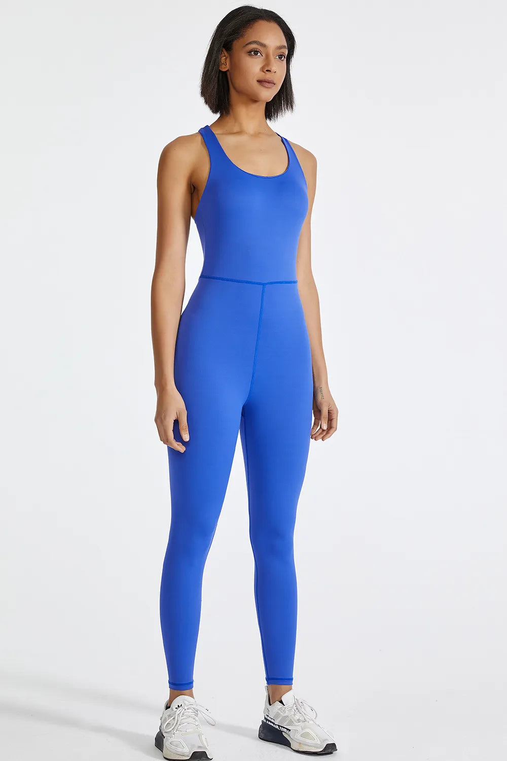 Blue active jumpsuit with wide straps, smooth fitted torso and tapered legs