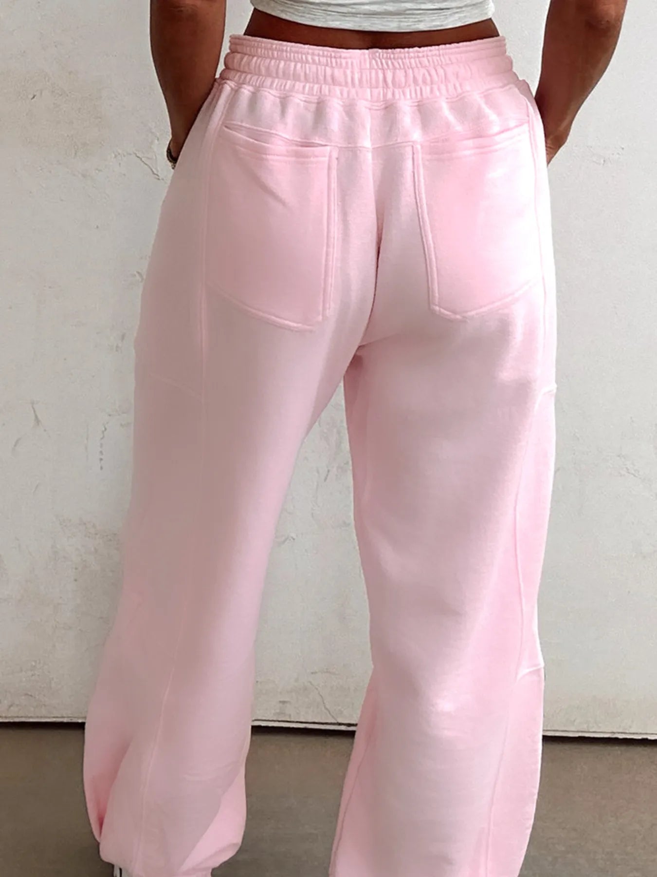 Pink drawstring sweatpants with elastic waistband and patch side pockets