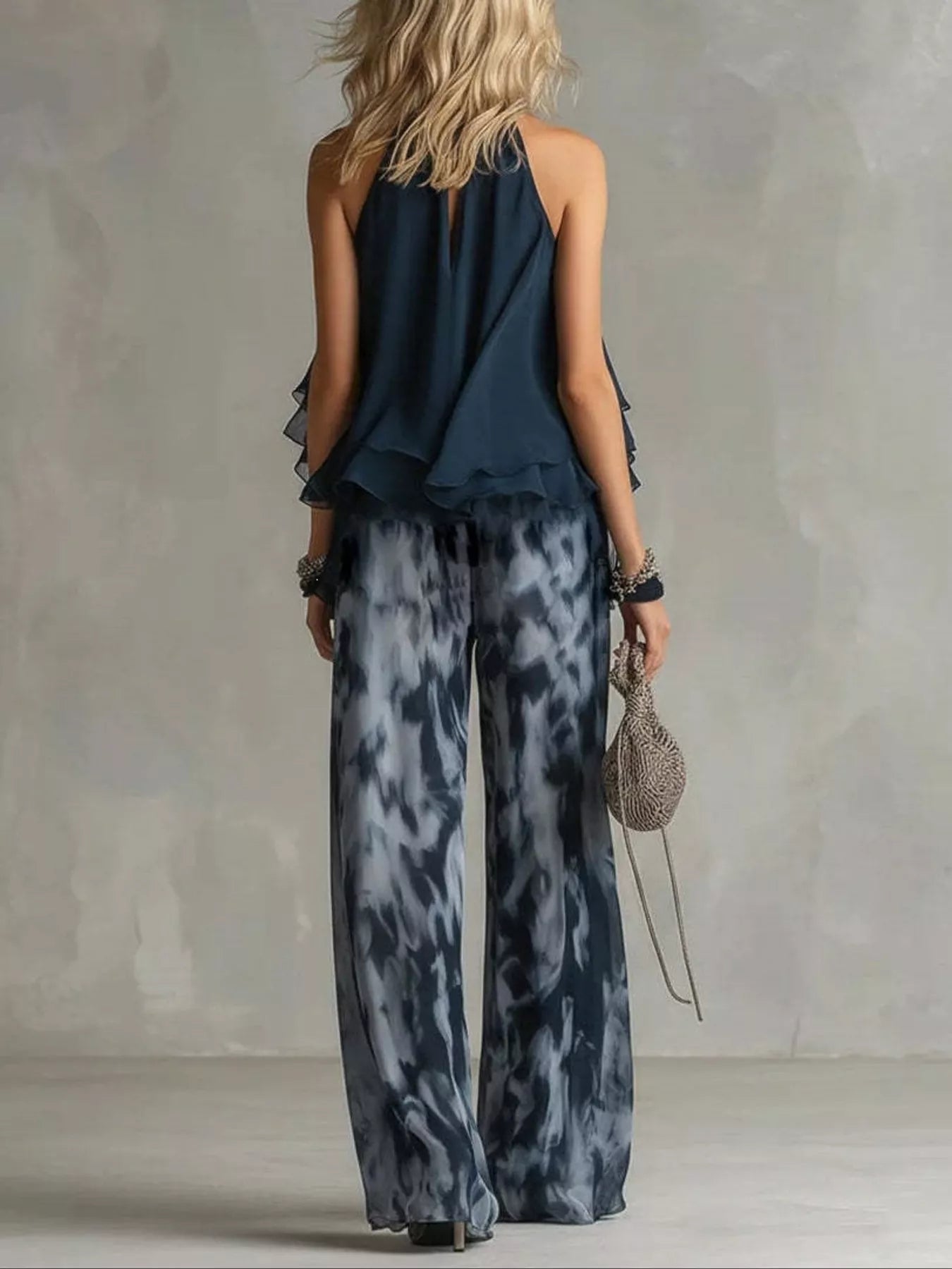Dark blue halter back ruffle top with tie-dye wide-leg pants, back view.