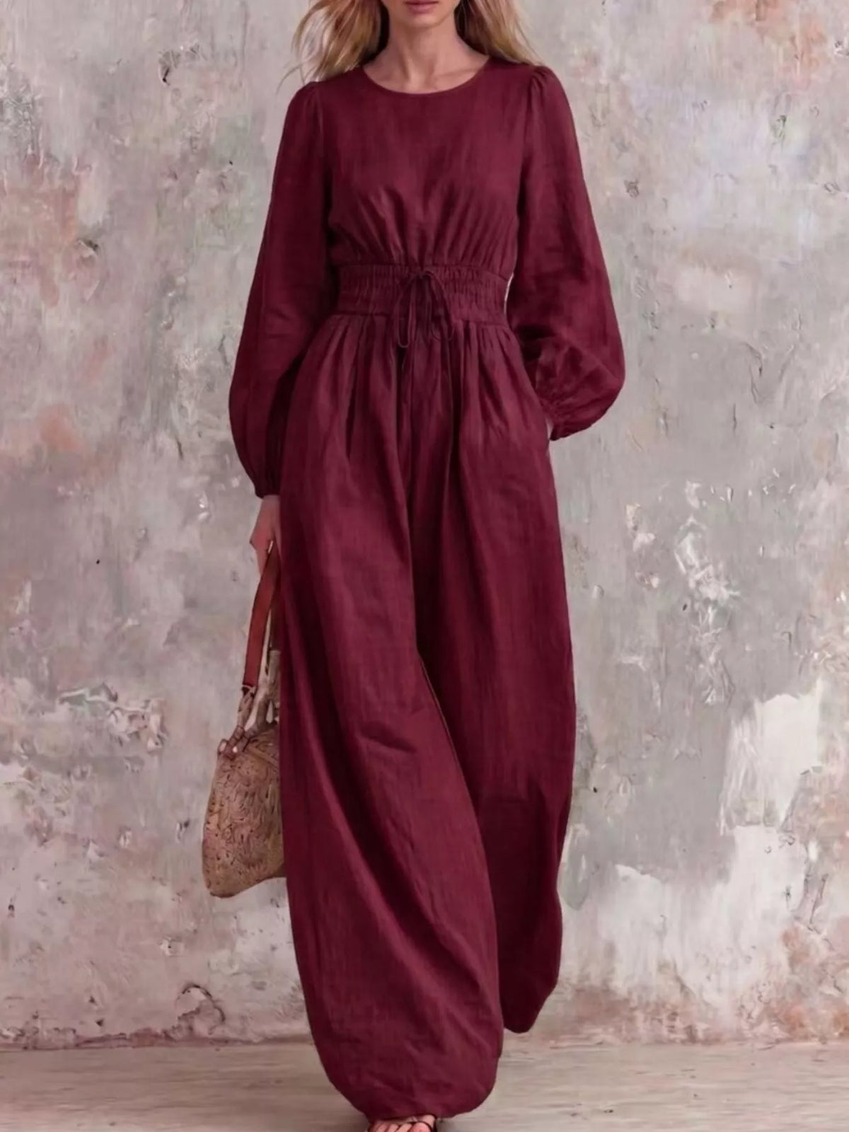 Smocked waist long-sleeve jumpsuit in wine red with gathered waist and wide legs