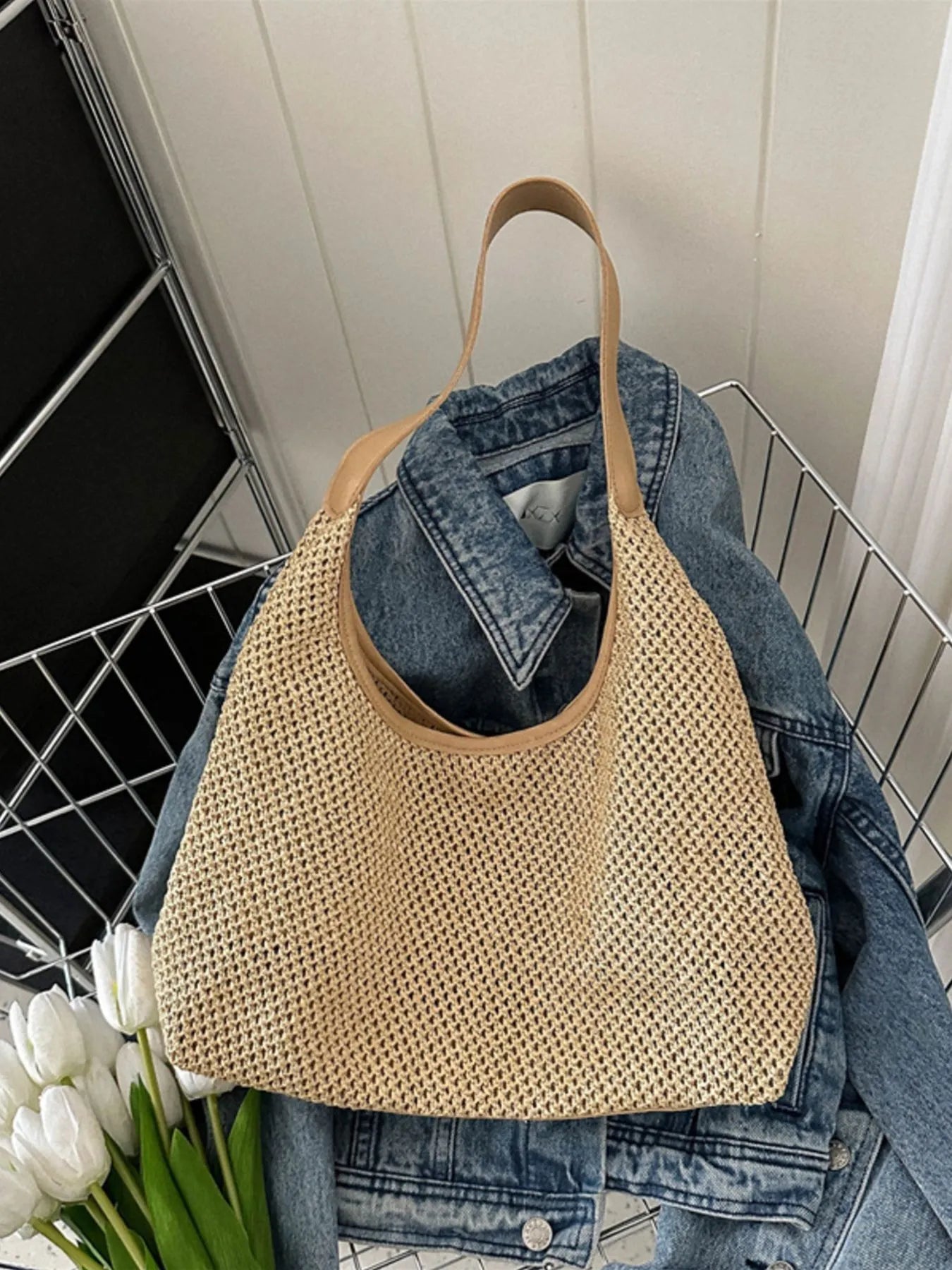 Woven straw shoulder bag in tan with tan handles, basket-weave texture