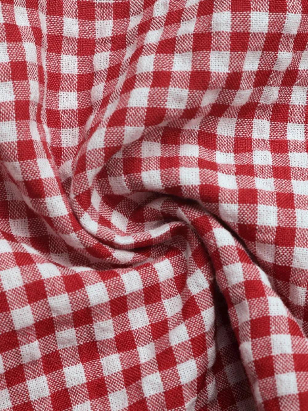 Deep red and white gingham fabric detail with woven texture