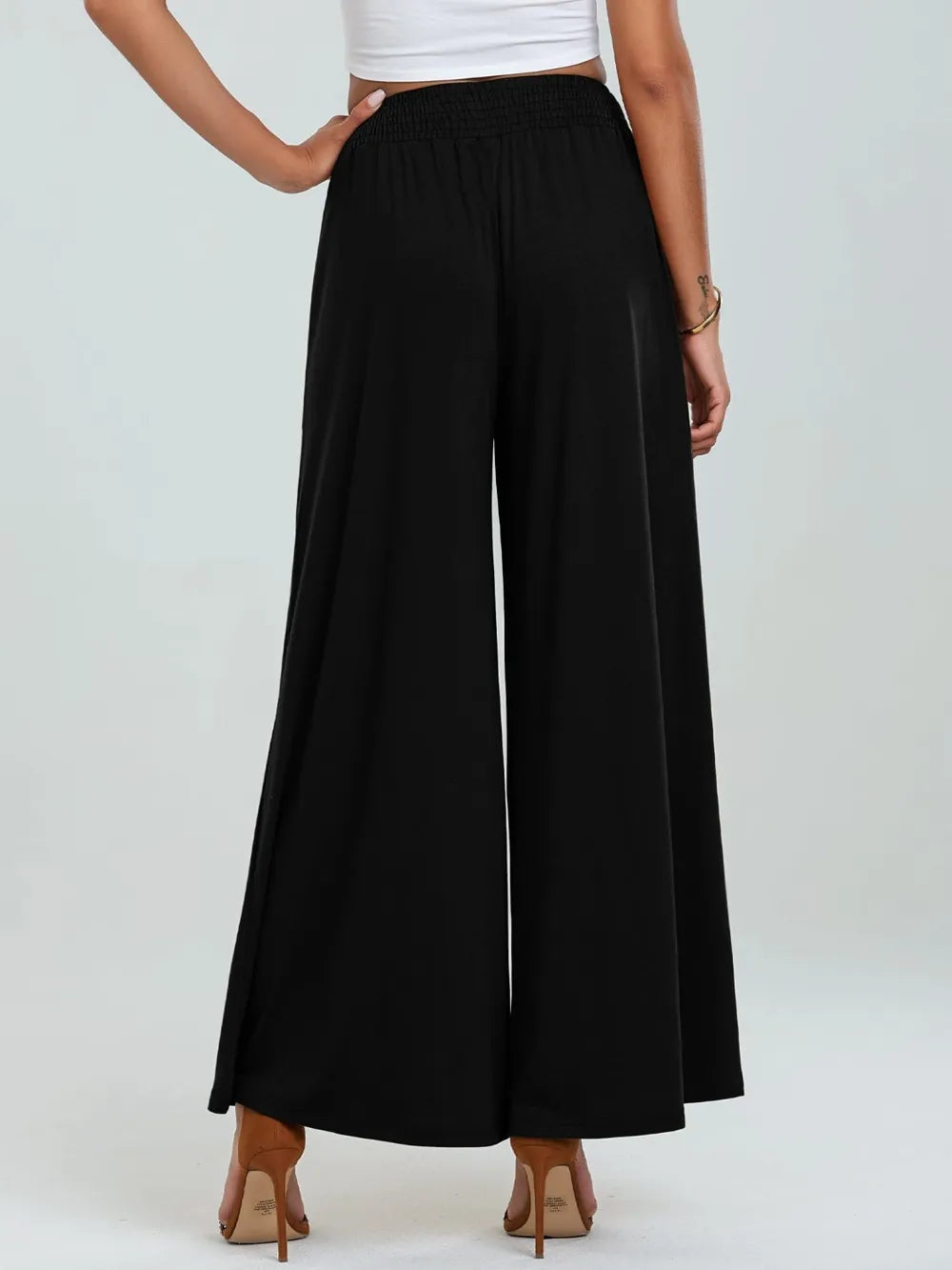 Black wide-leg pants with elastic waist and side pockets, back view