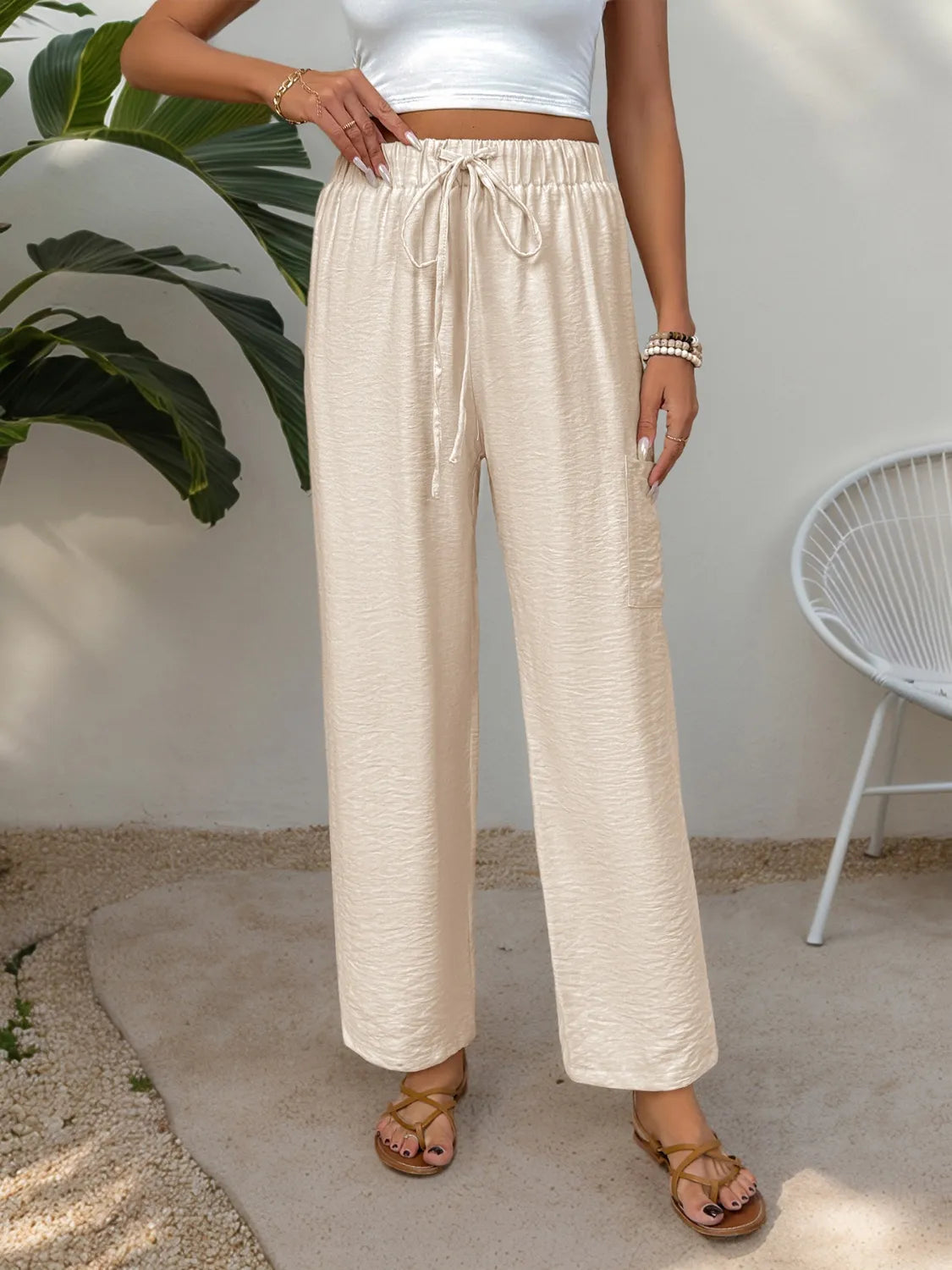 Cream drawstring wide-leg pants with elastic waist and relaxed, straight legs