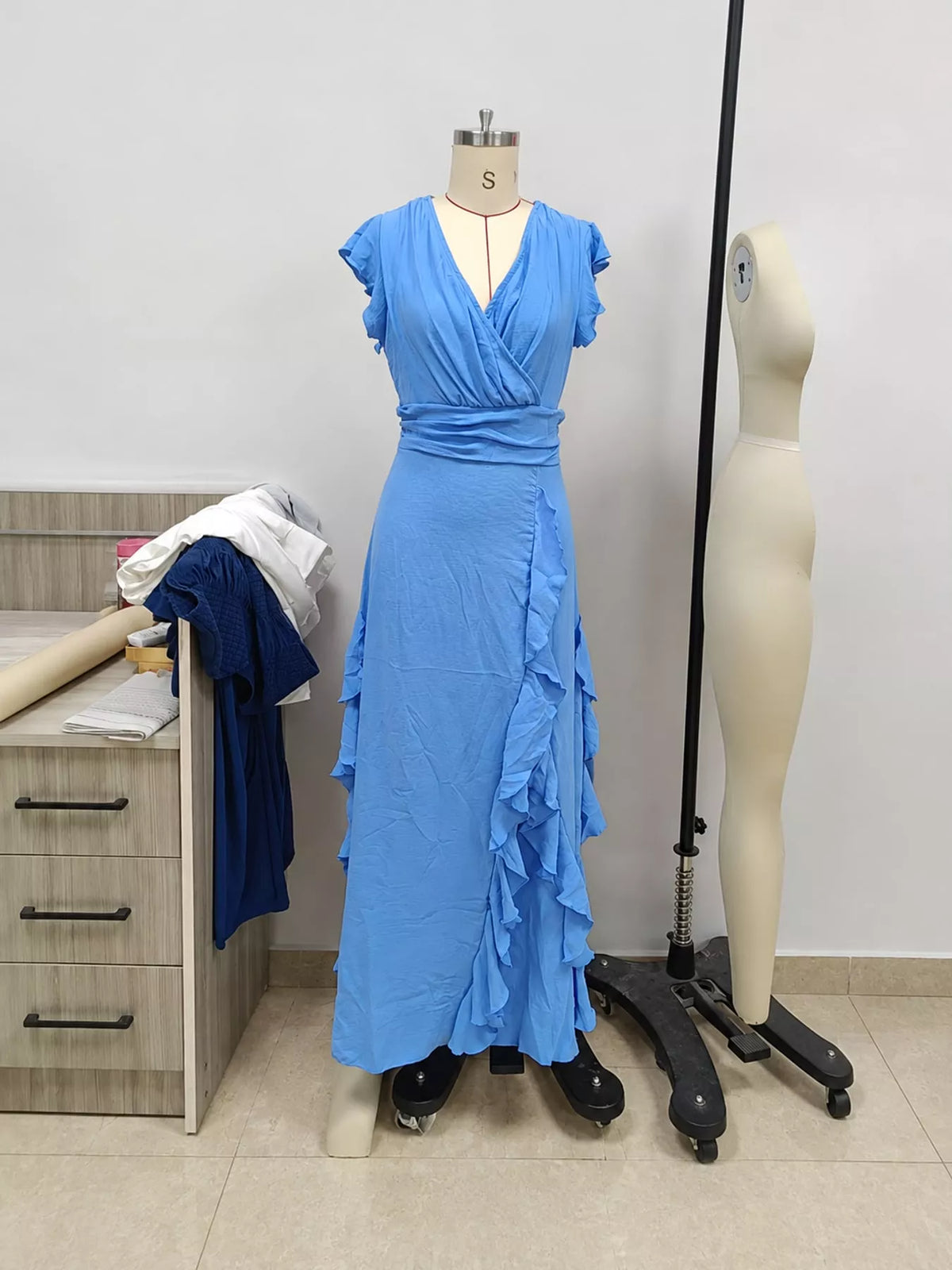 Sky blue sleeveless maxi dress on mannequin, ruffled high waist and flutter sleeves
