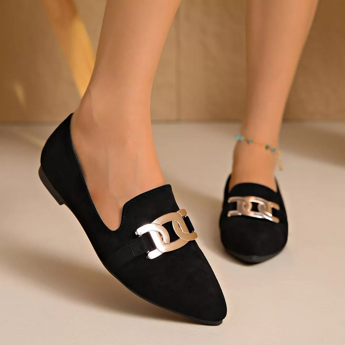 Black suede pointed loafers with gold-toned chain link buckle