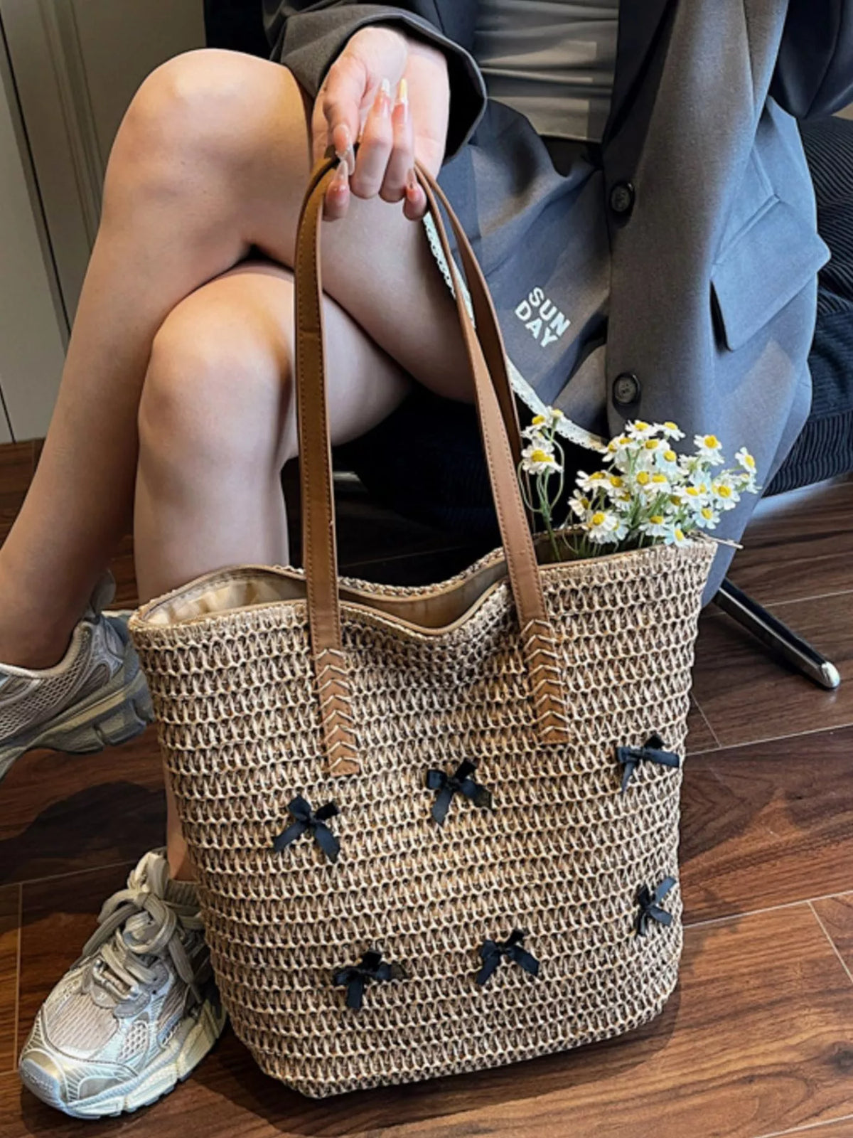 Caramel woven straw tote bag with bow applique pattern, leather-look handles