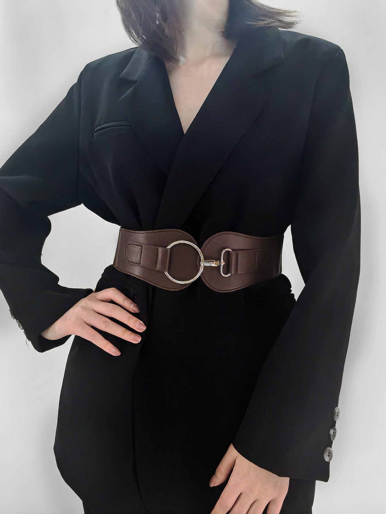 Wide elastic vegan leather belt in caramel brown with oval metal buckle at waist