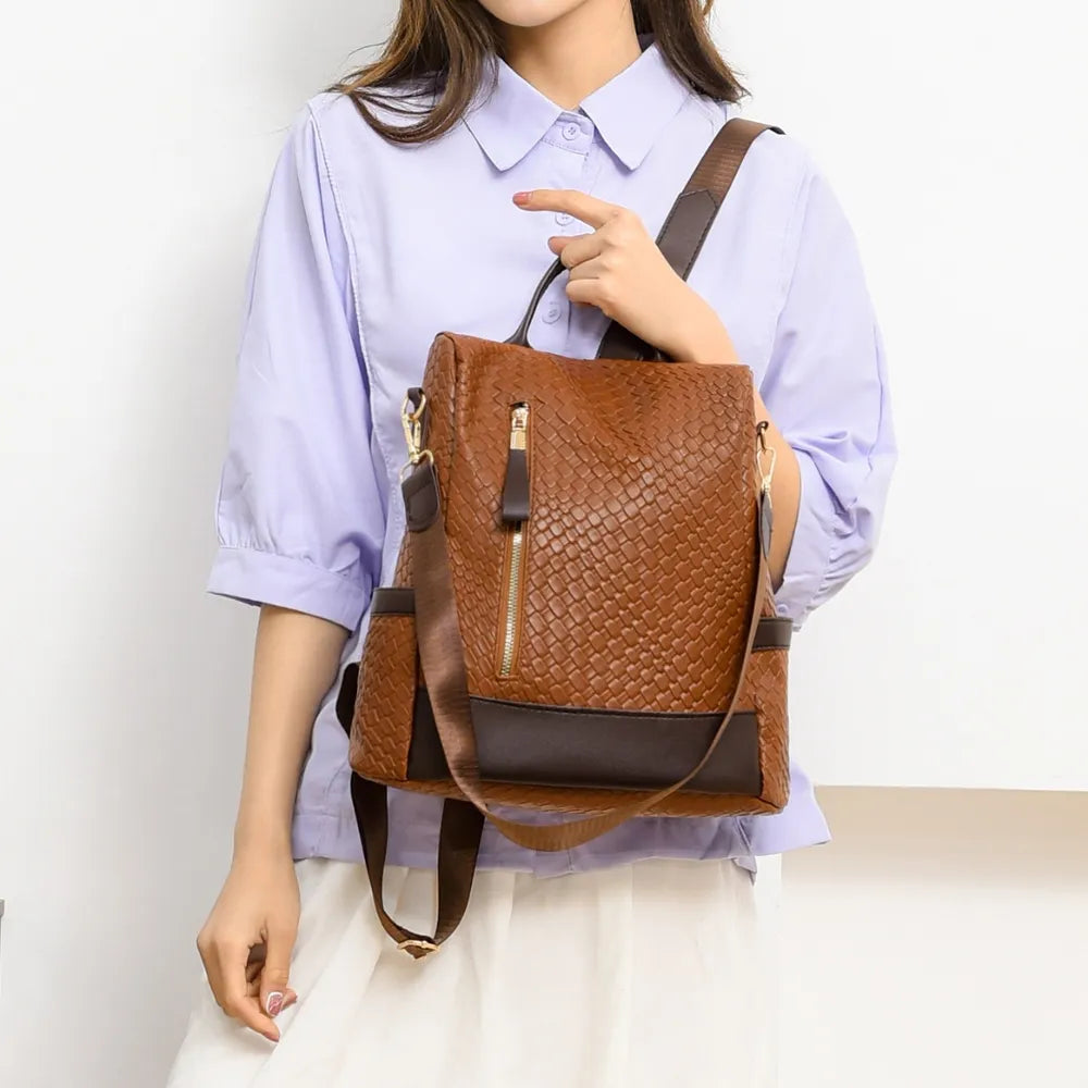 Vegan leather backpack bag in brown with braided pattern and dark bottom trim.