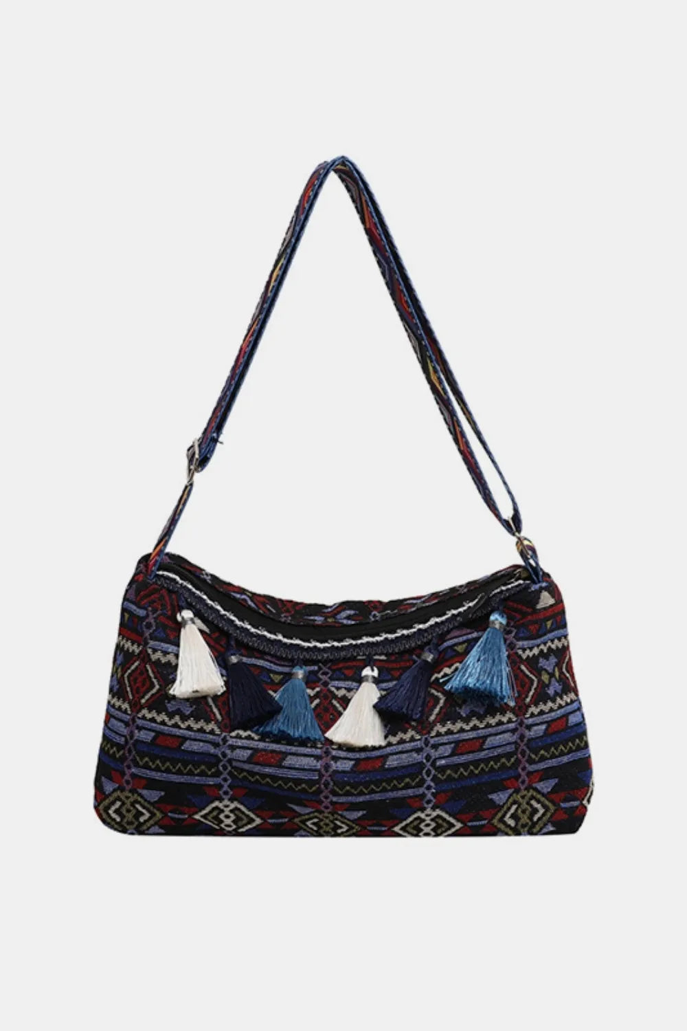 Tassel shoulder bag with adjustable strap, navy patterned fabric and white hanging tassels.