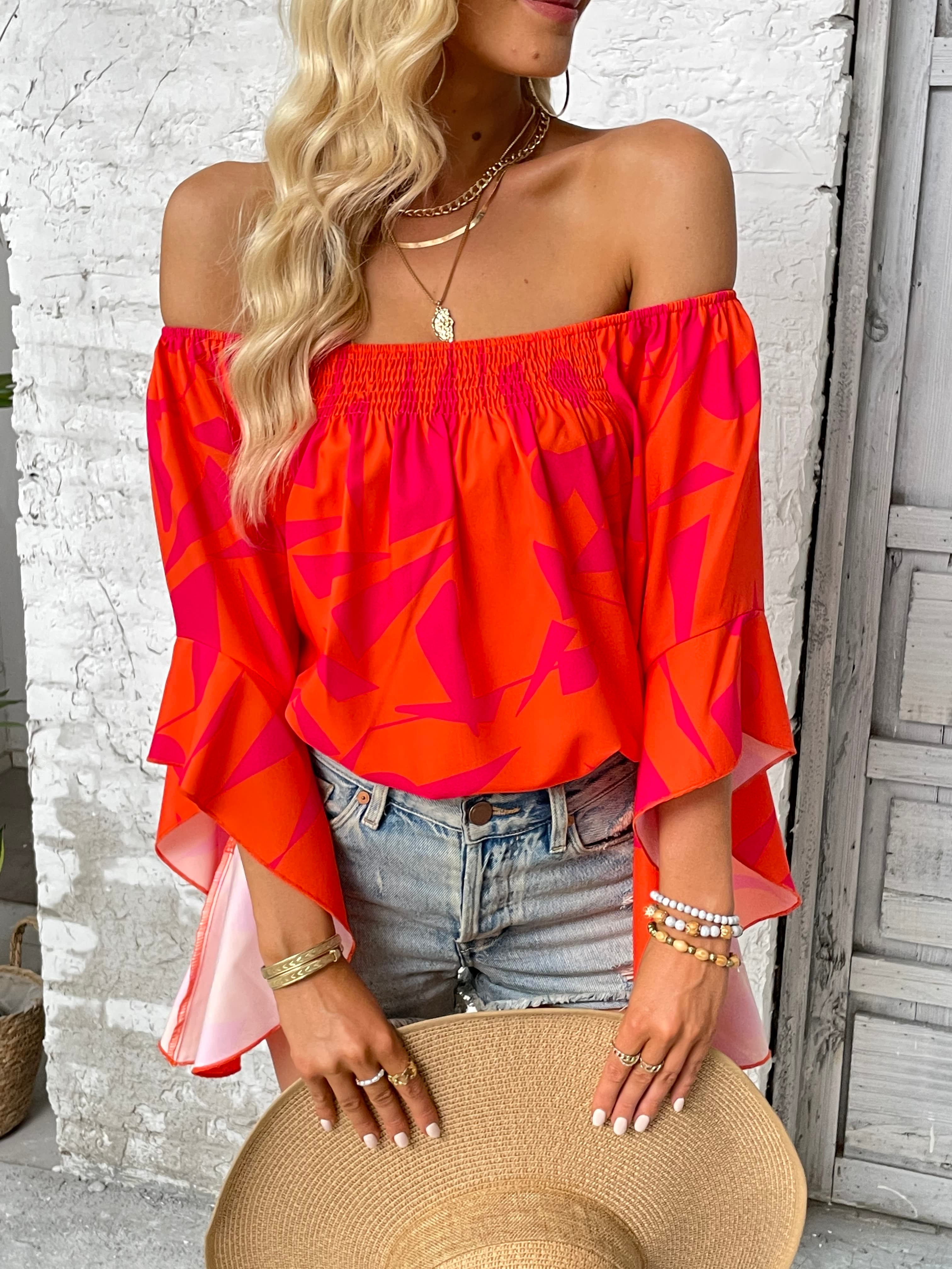 Off-shoulder bell sleeve blouse in bright orange with red abstract pattern
