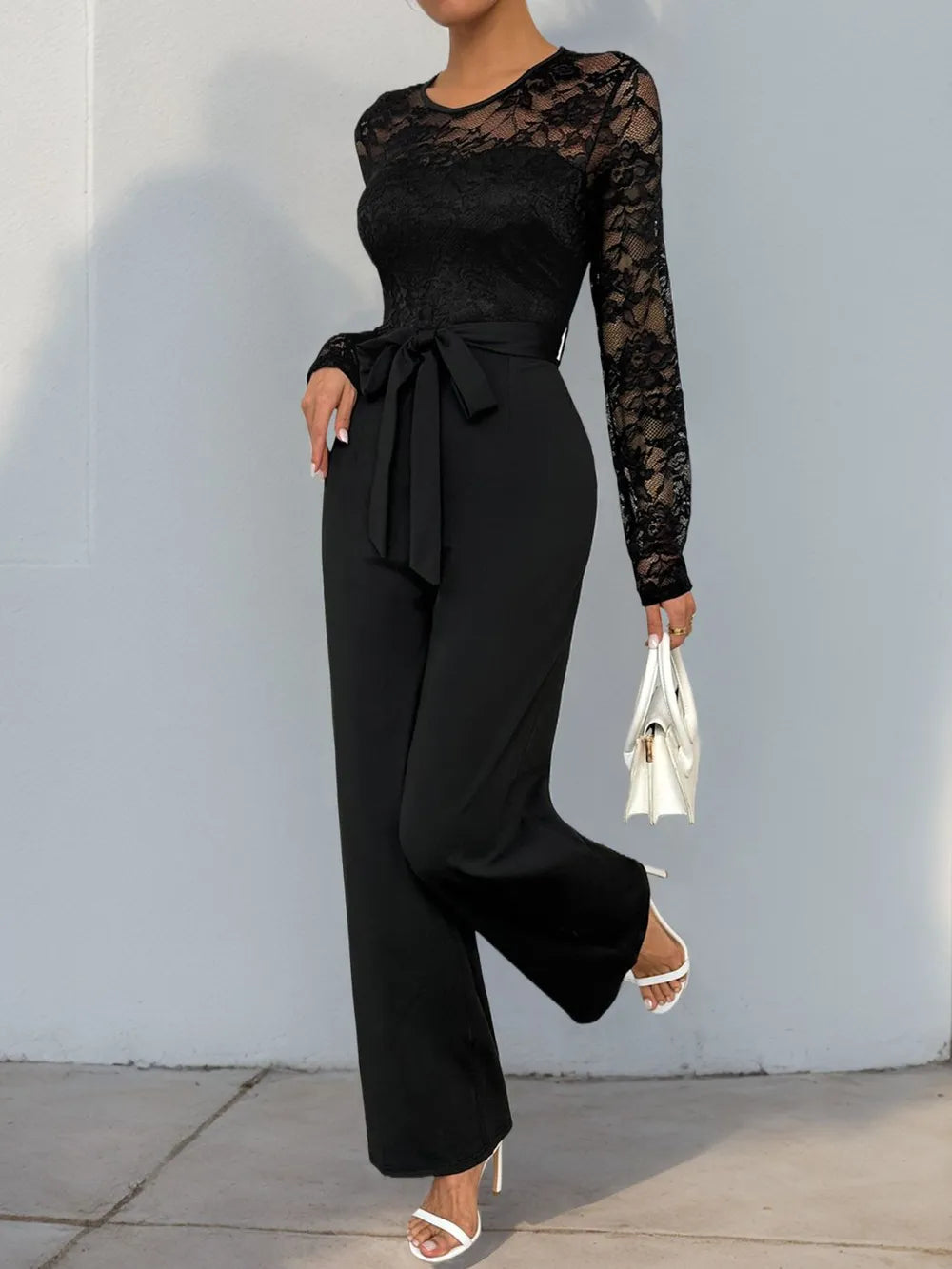Black lace long-sleeve jumpsuit with round neck, belted waist, wide-leg silhouette