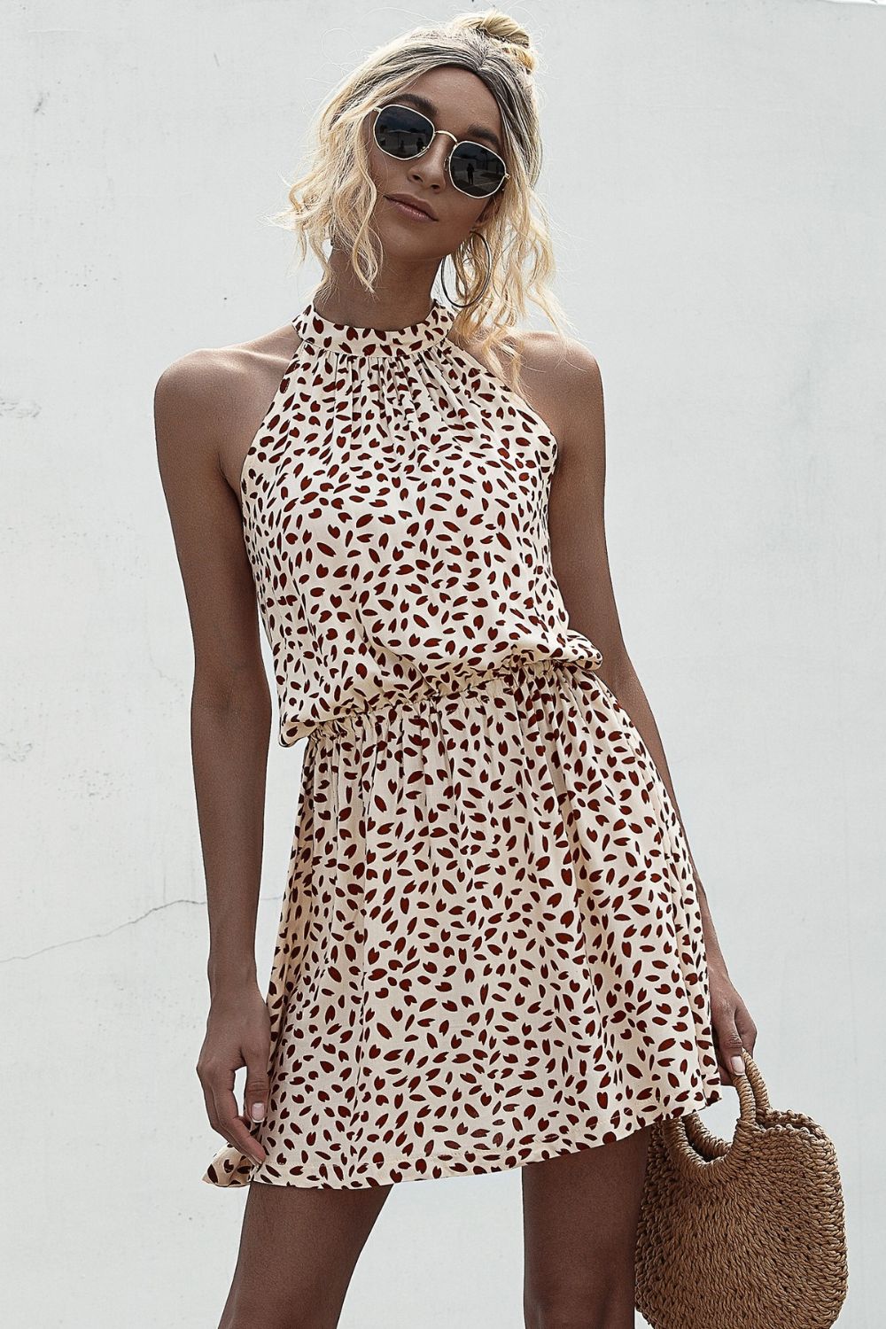Tan printed halter mini dress with Grecian neckline and gathered waist
