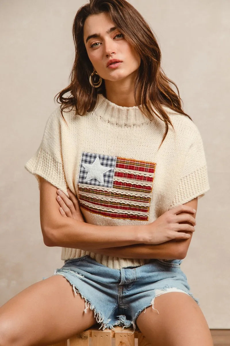 Oatmeal knit sweater with drop shoulders, short sleeves, and American flag patch front